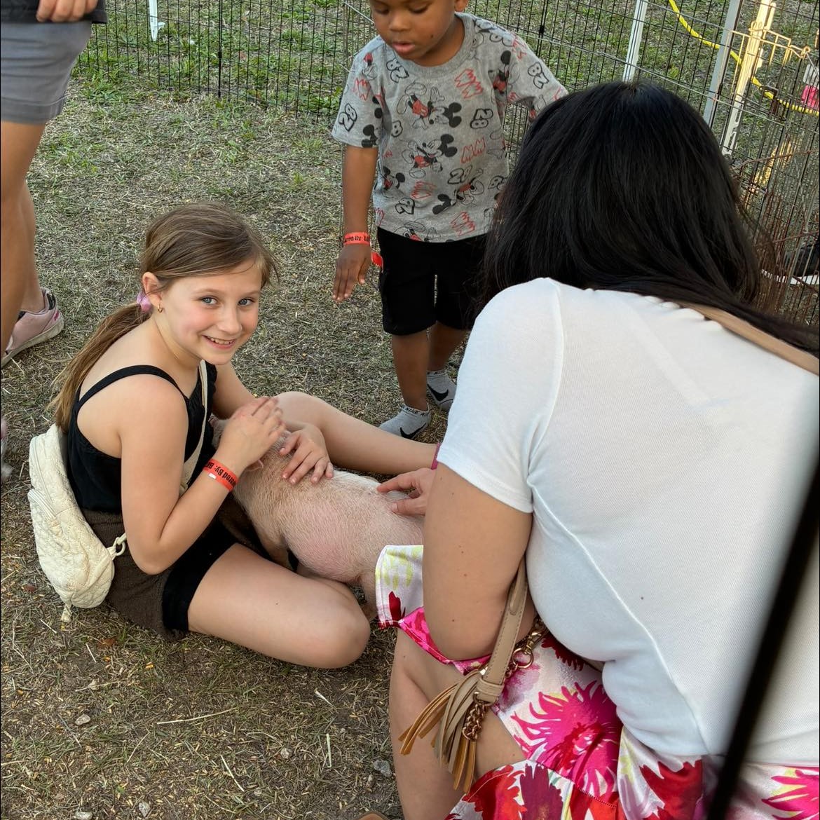 Girl petting a baby lamb at A Traveling Farm mobile petting zoo birthday party Port Orange FL